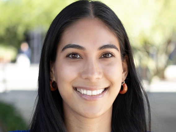 Portrait of smiling woman in electric blue shirt and long, straight dark hair