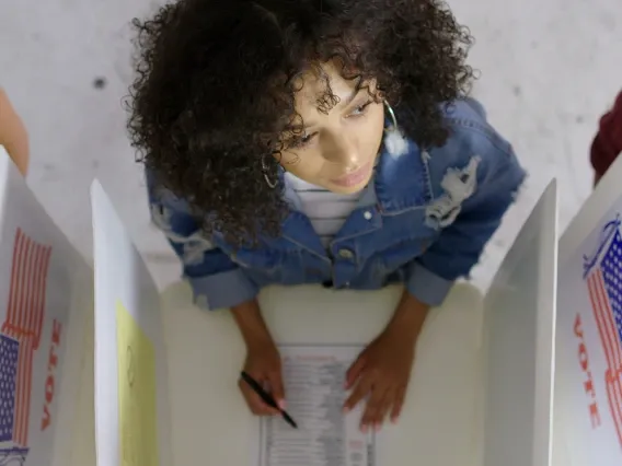 young woman looking up from her ballot