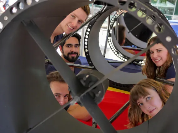 Dr. Vishnu Reddy's Design Day team poses with one of two telescopes they designed and built. This one will be installed in the Kuiper Building on University of Arizona campus and will be used to monitor the movement of satellites.