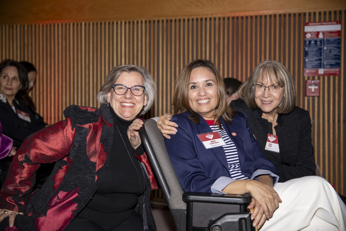 Three seated Women of Impact honorees pose for a picture.