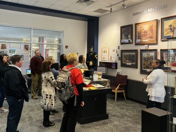 A group of people looks at an exhibition featuring the Buffalo Soldiers.