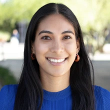 Portrait of smiling woman in electric blue shirt and long, straight dark hair