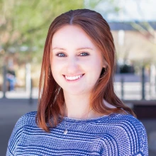 College student with auburn hair and blue striped sweather